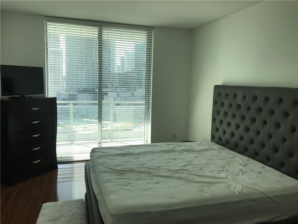 90 Southwest 3rd Street, Unit 1802 Miami, FL 33130 - Photo 11 of 50 a bedroom with a bed and a flat tv screen on dresser