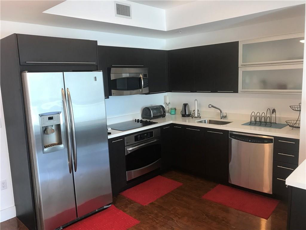 90 Southwest 3rd Street, Unit 1802 Miami, FL 33130 - Photo 2 of 50 a kitchen with stainless steel appliances kitchen island granite countertop a refrigerator and a stove top oven