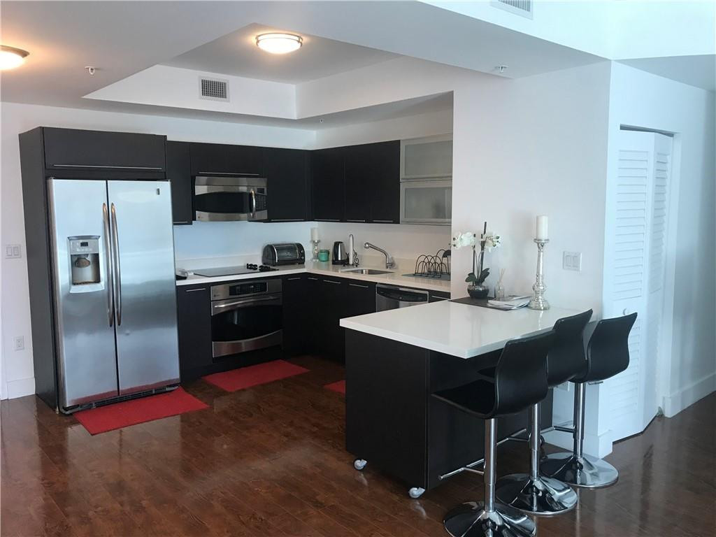90 Southwest 3rd Street, Unit 1802 Miami, FL 33130 - Photo 3 of 50 a kitchen with stainless steel appliances a sink and a refrigerator