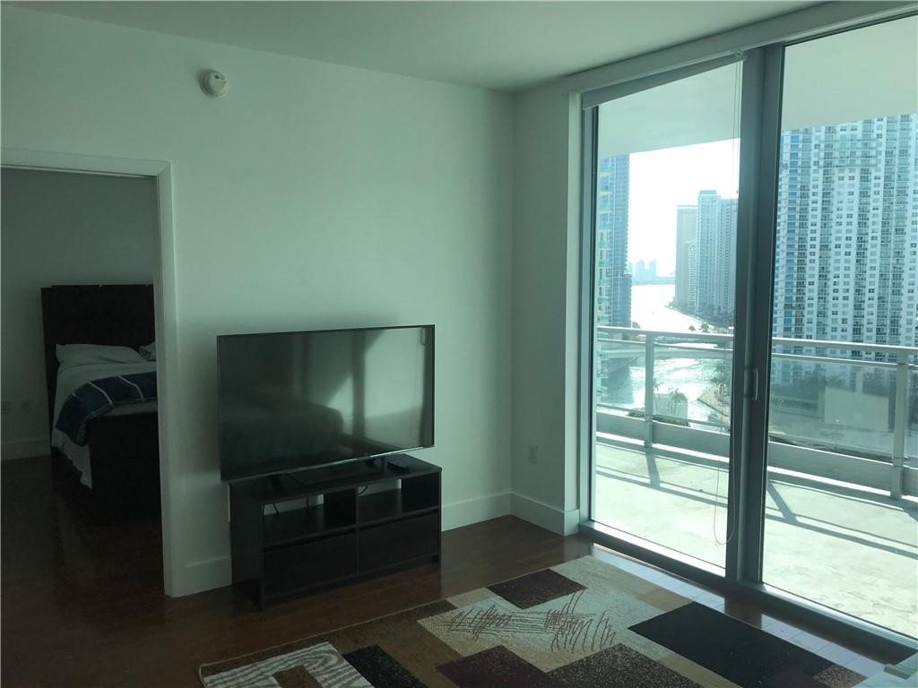 90 Southwest 3rd Street, Unit 1802 Miami, FL 33130 - Photo 4 of 50 a living room with furniture and a flat screen tv