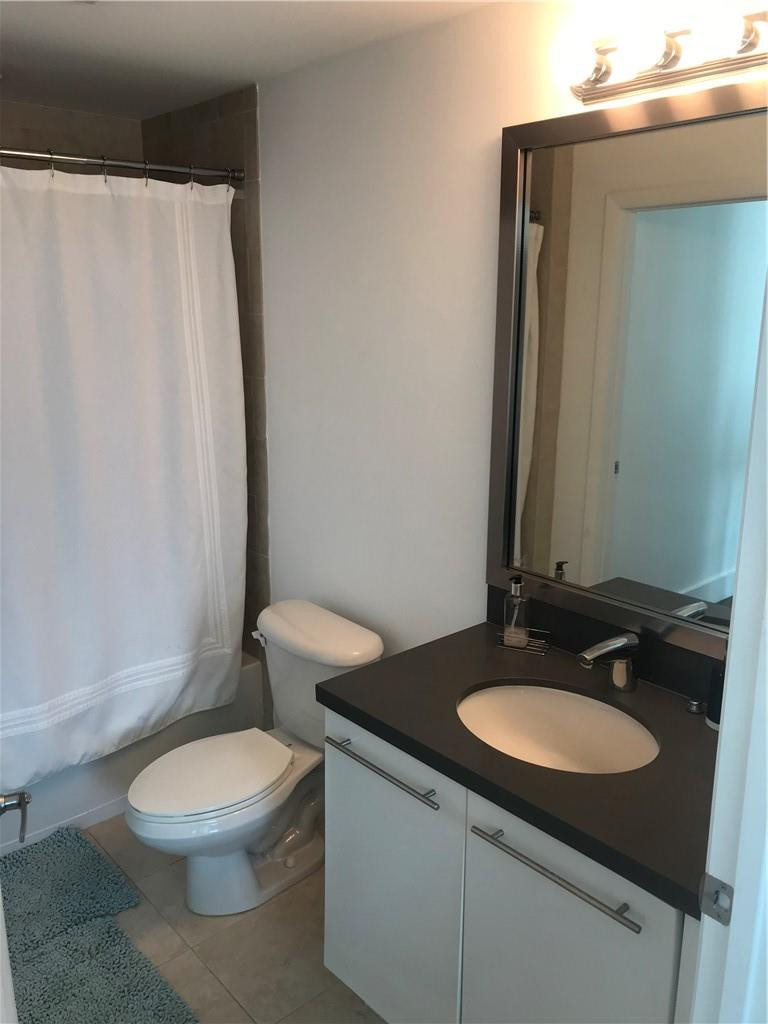 90 Southwest 3rd Street, Unit 1802 Miami, FL 33130 - Photo 8 of 50 a bathroom with a granite countertop sink toilet and a mirror