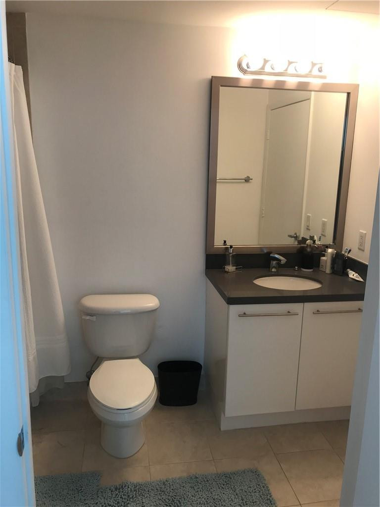 90 Southwest 3rd Street, Unit 1802 Miami, FL 33130 - Photo 10 of 50 a bathroom with a toilet a sink and a mirror