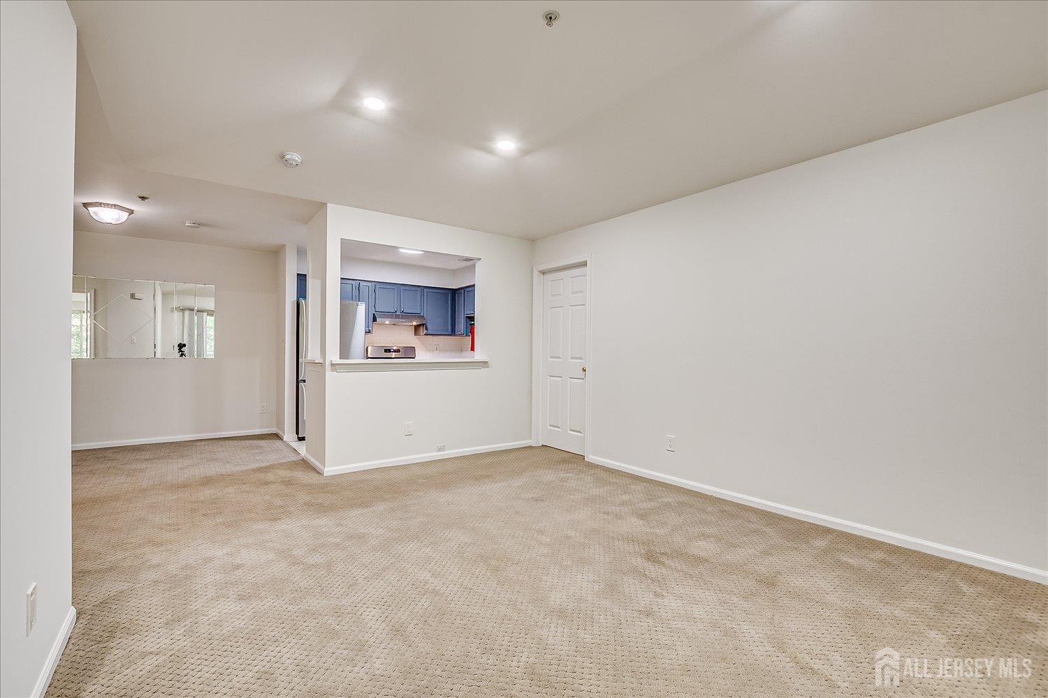 936 Waterford Drive Edison, NJ 08817 - Photo 11 of 29 an empty room with a white wall and a refrigerator