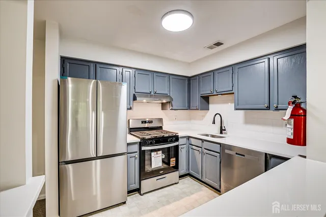 a kitchen with appliances a sink and a stove