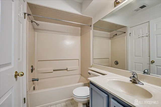 a view of a house with a yard plants and large tree