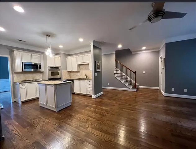a large kitchen with stainless steel appliances kitchen island a large counter top and a stove