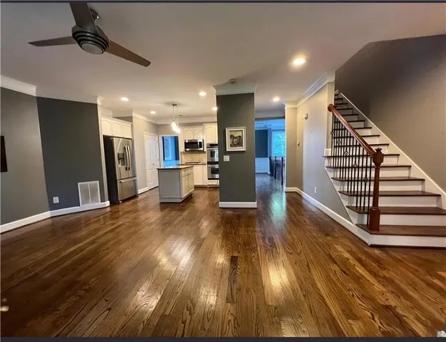 a view of a living room with wooden floor and staircase