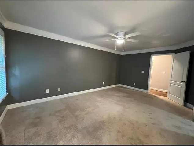 an empty room with a ceiling fan and a window