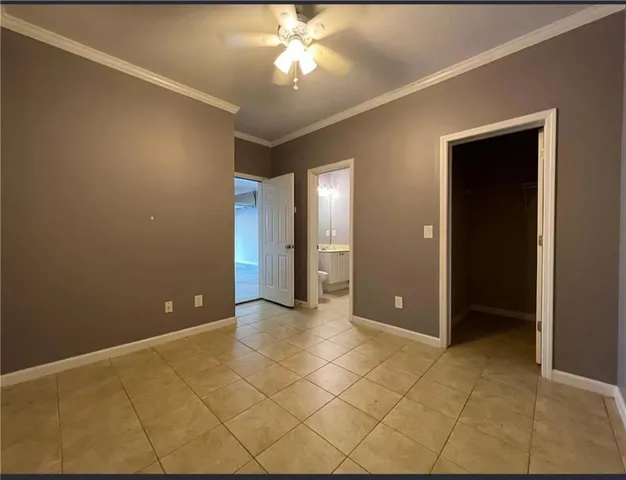 a view of an empty room with window and bathroom