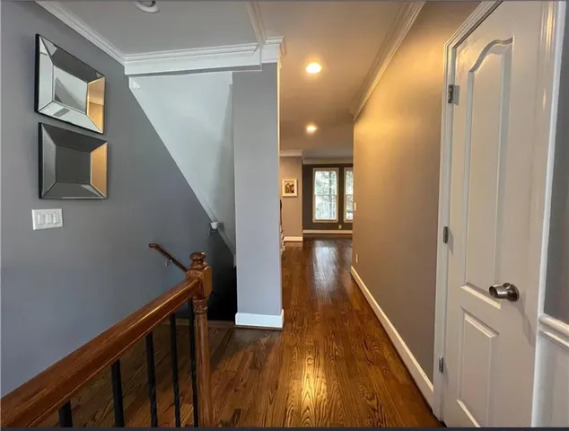 a view of a hallway with wooden floor and stairs