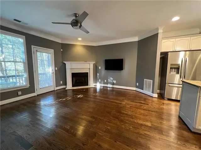 a view of empty room with wooden floor and fireplace