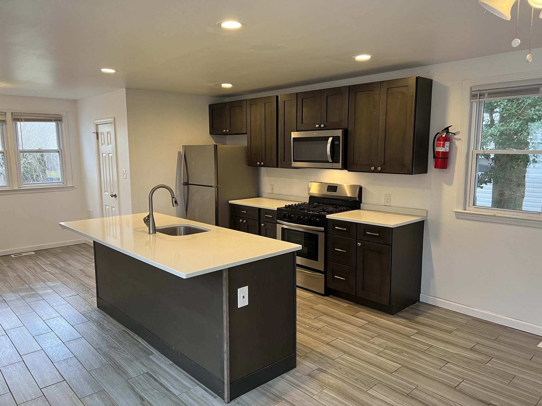 201 Linden Lane Rio Grande, NJ 08242 - Photo 6 of 18 a kitchen with stainless steel appliances a sink a stove a refrigerator cabinets and a dining table