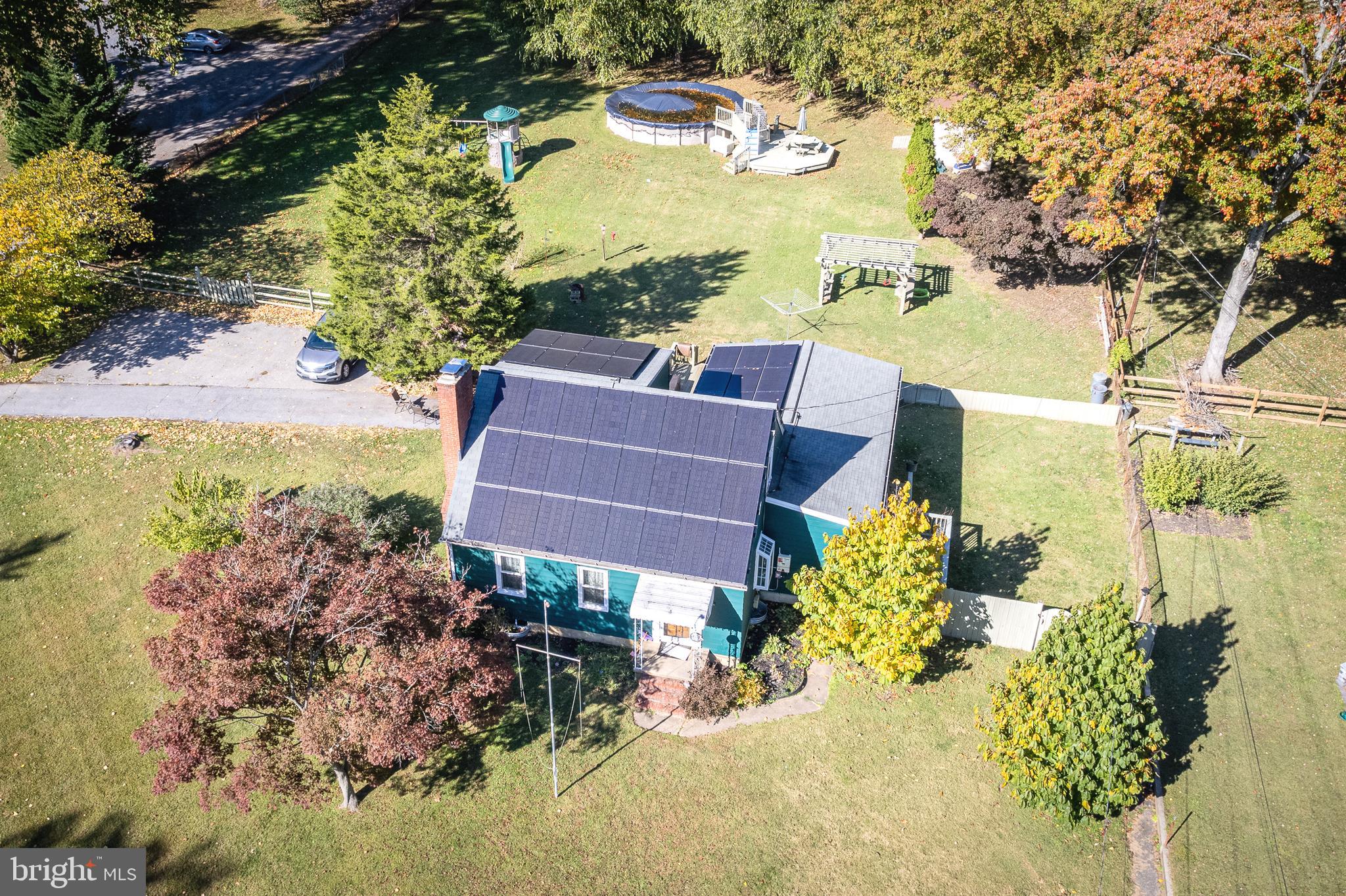 an aerial view of a house with a yard swimming pool and outdoor seating