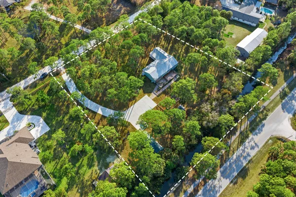 a view of a building with a big yard and large trees