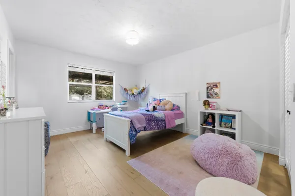 a bedroom with a bed dresser and a chair