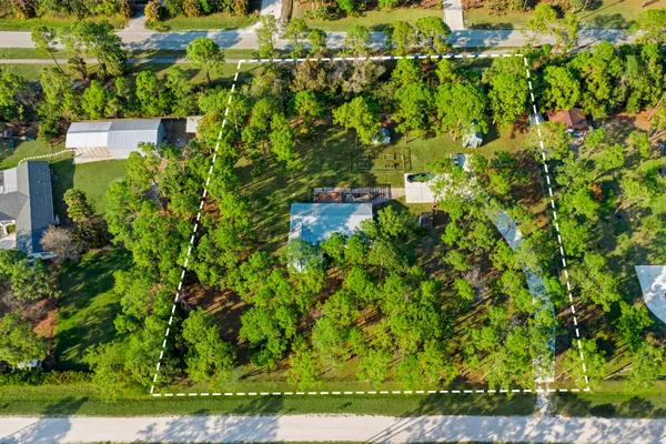 an aerial view of residential houses with outdoor space and trees