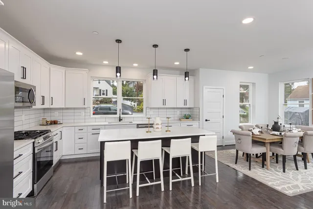 a kitchen with stainless steel appliances a stove a white cabinets and a sink