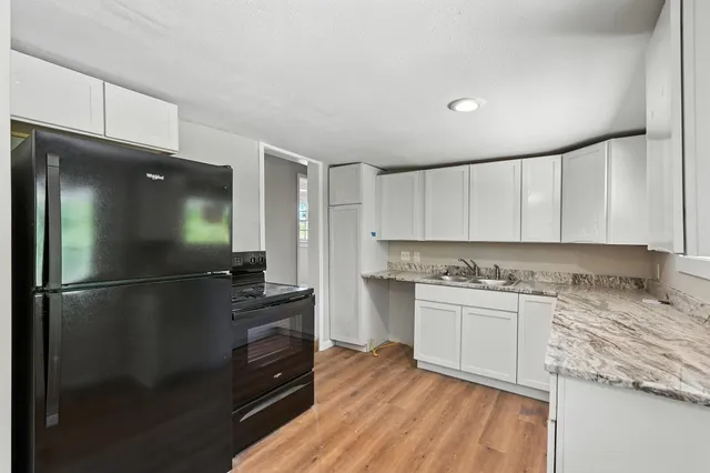 a kitchen with a refrigerator and a stove top oven