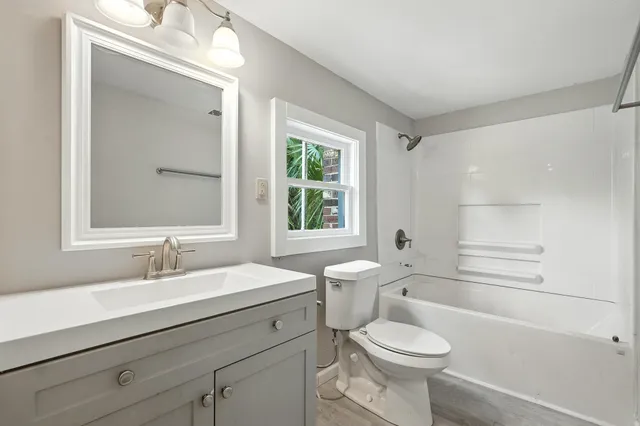 a bathroom with a sink toilet vanity and tub