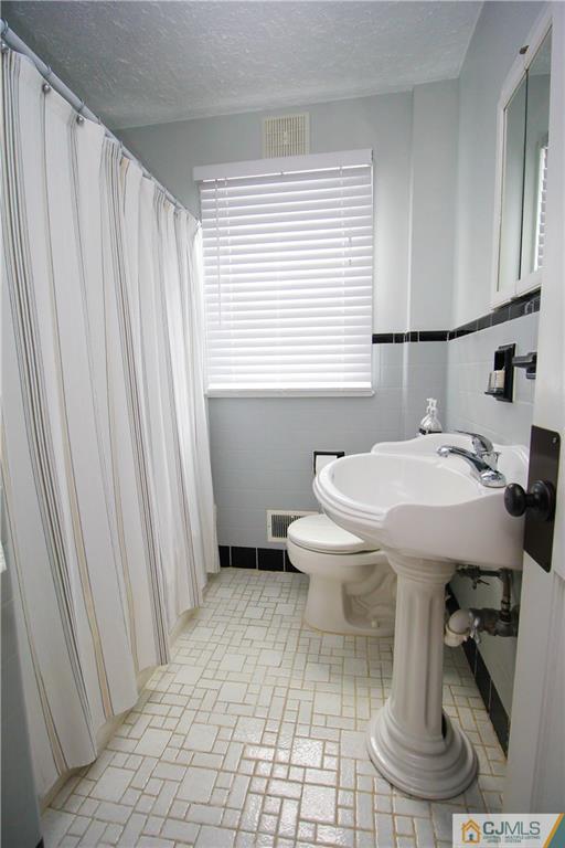 503 Crows Mill Road Fords, NJ 08863 - Photo 9 of 19 a bathroom with a sink a toilet and a window