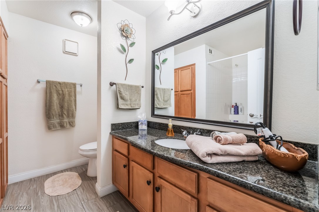 3145 East Flamingo Road, Unit 1092 Las Vegas, NV 89121 - Photo 16 of 33 Granite counters and wood cabinets highlight this well-appointed bathroom vanity.