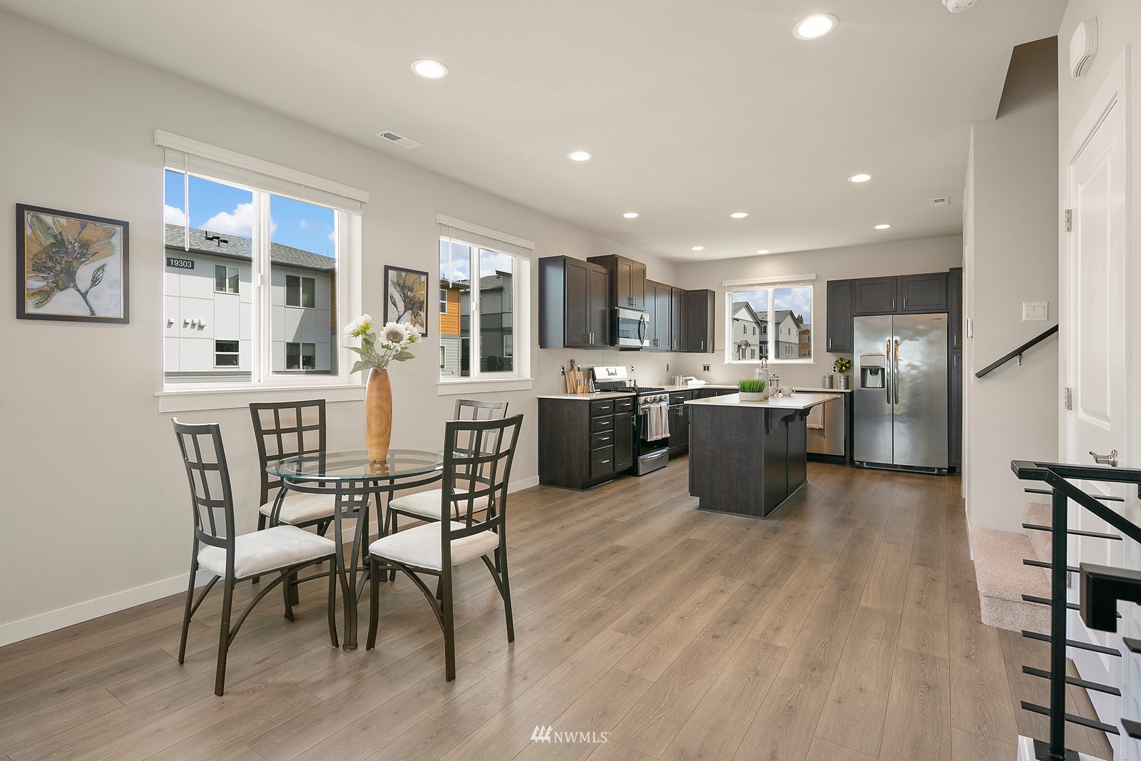 3521 193rd Street Southeast, Unit F Bothell, WA 98012 - Photo 8 of 29 a kitchen with stainless steel appliances kitchen island granite countertop a table chairs sink and cabinets