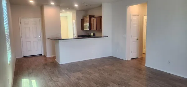 an empty room with wooden floor and mirror