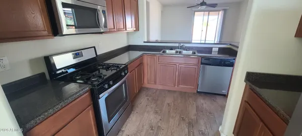 a kitchen with stainless steel appliances granite countertop a stove a sink and a microwave