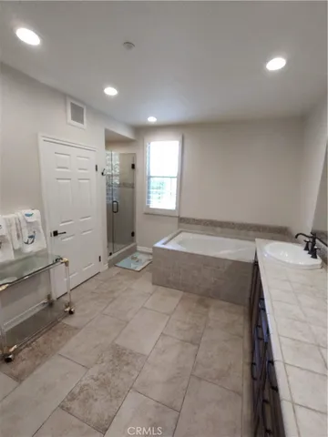 a large white kitchen with a sink a toilet and a mirror
