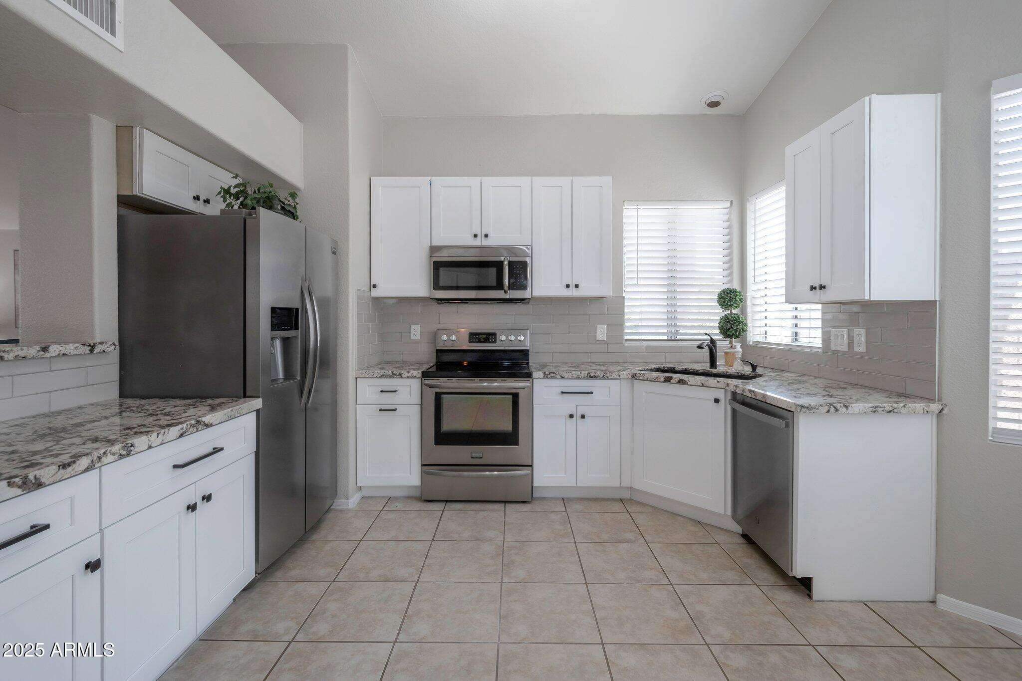 839 West Silver Creek Road Gilbert, AZ 85233 - Photo 1 of 15 a kitchen with granite countertop a stove sink and refrigerator