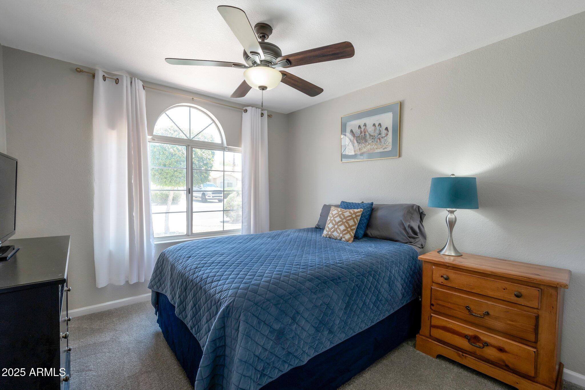 839 West Silver Creek Road Gilbert, AZ 85233 - Photo 9 of 15 a bedroom with a bed and a chandelier
