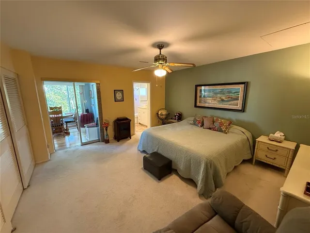 a spacious bedroom with a bed and a chandelier