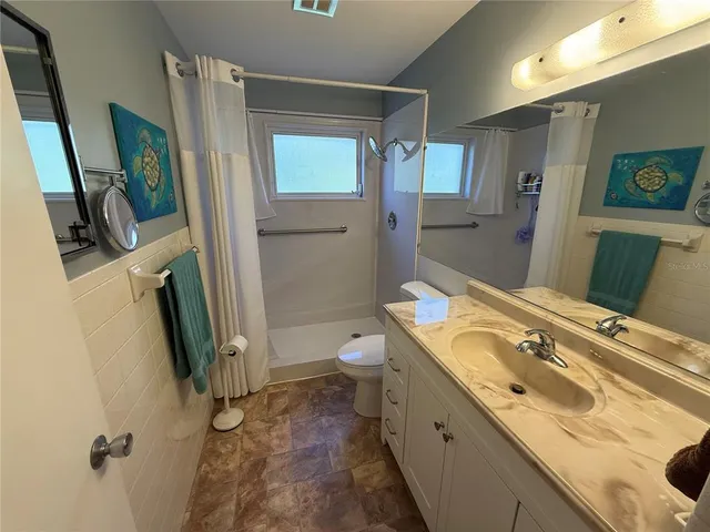 a spacious bathroom with a granite countertop sink toilet and shower