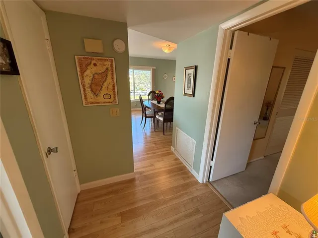 a view of a hallway with furniture and wooden floor