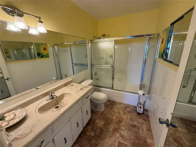 a bathroom with a double vanity sink toilet mirror and shower