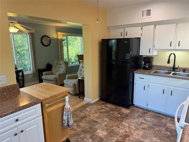 a kitchen with stainless steel appliances granite countertop a refrigerator sink and cabinets