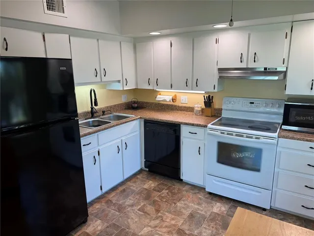 a kitchen with a sink stove and refrigerator