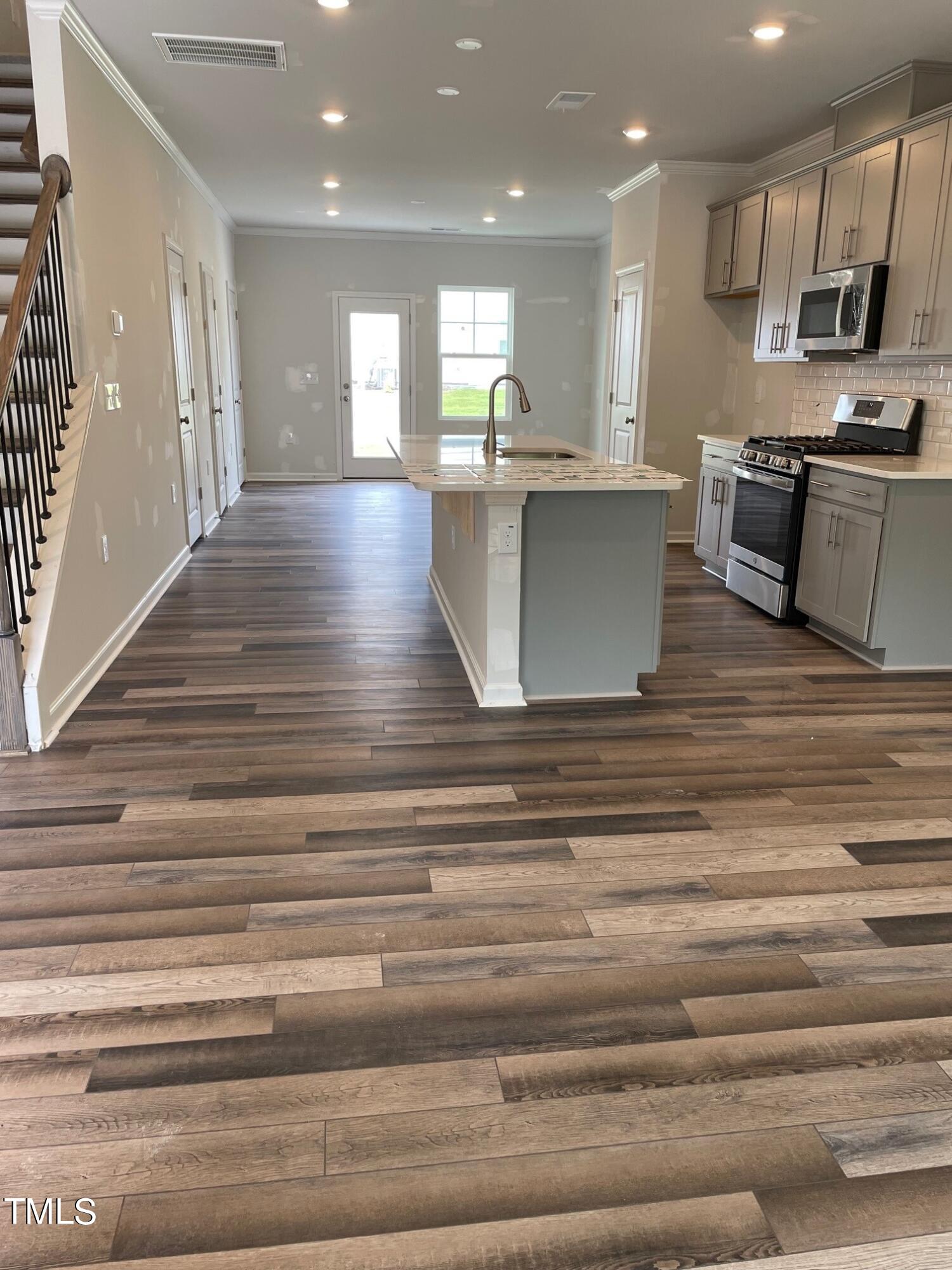 4921 Microcline Trail, Unit 790 Raleigh, NC 27610 - Photo 6 of 46 a view of kitchen with kitchen island stainless steel appliances wooden floor and stove