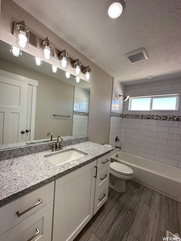 1171 West 2330 North Helper, UT 84526 - Photo 21 of 26 Bathroom with vanity, washtub / shower combination, and a textured ceiling