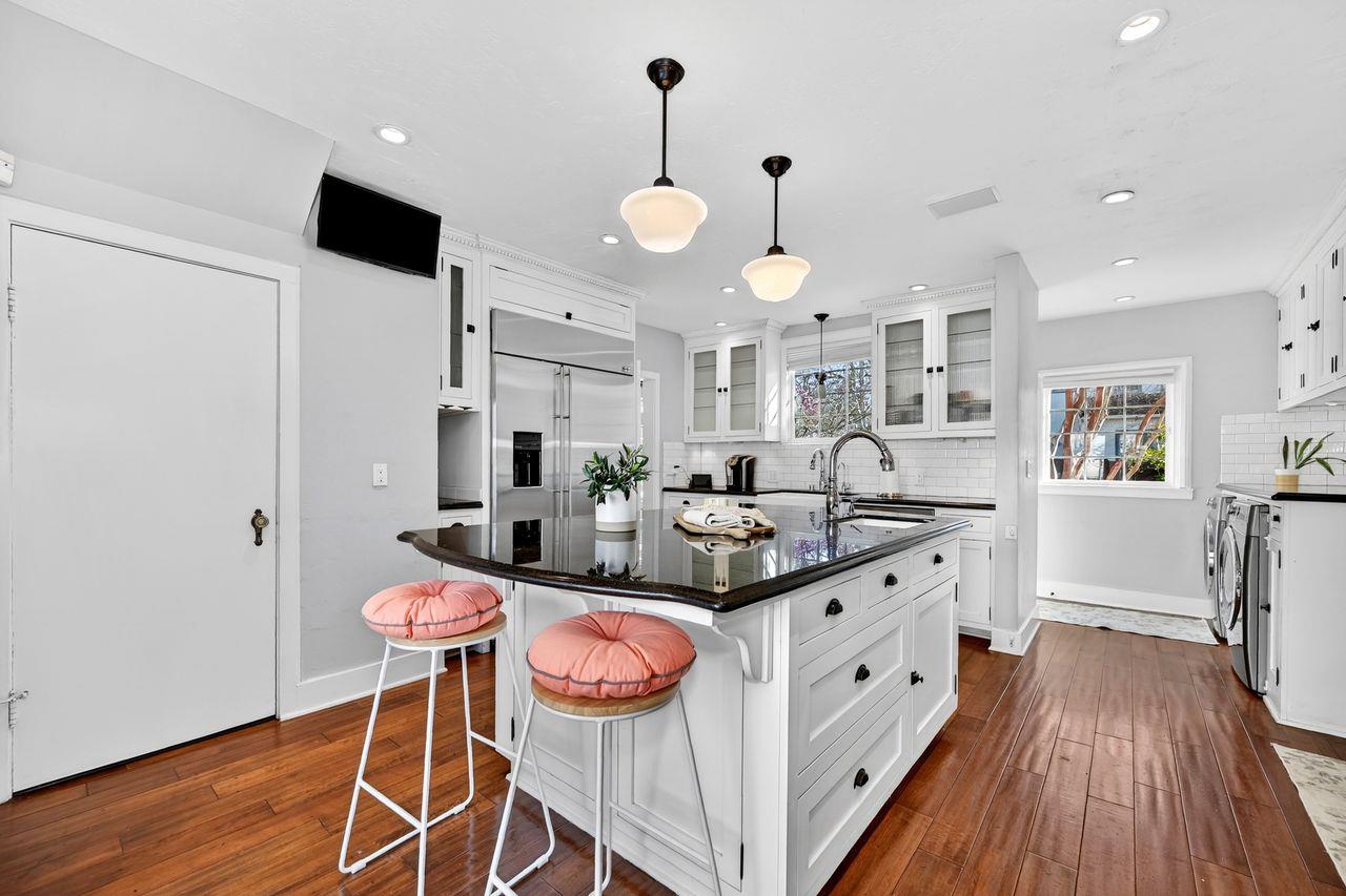 1716 Sutterville Road Sacramento, CA 95822 - Photo 17 of 57 a kitchen with stainless steel appliances a stove a sink dishwasher and a dining table with wooden floor