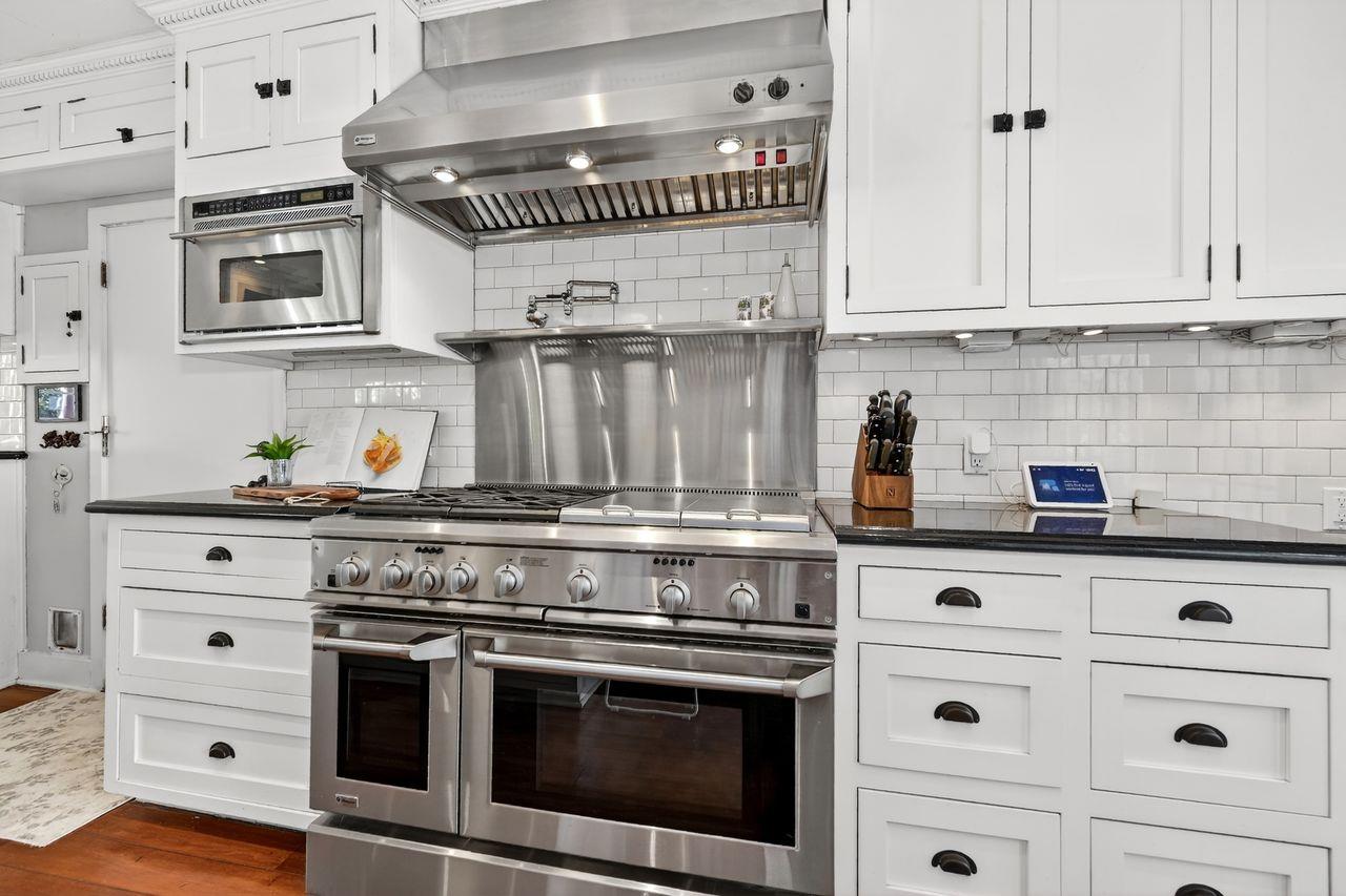 1716 Sutterville Road Sacramento, CA 95822 - Photo 19 of 57 a kitchen with stainless steel appliances granite countertop a stove and white cabinets