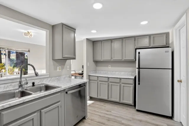 a kitchen with a sink refrigerator and cabinets