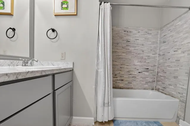 a bathroom with a tub sink and mirror