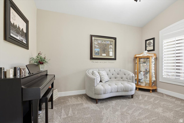 3123 East Riverdale Road Preston, ID 83263 - Photo 5 of 52 Den - Carpeted room with vaulted ceilings, featuring a large window with white plantation shutters, and light-toned walls