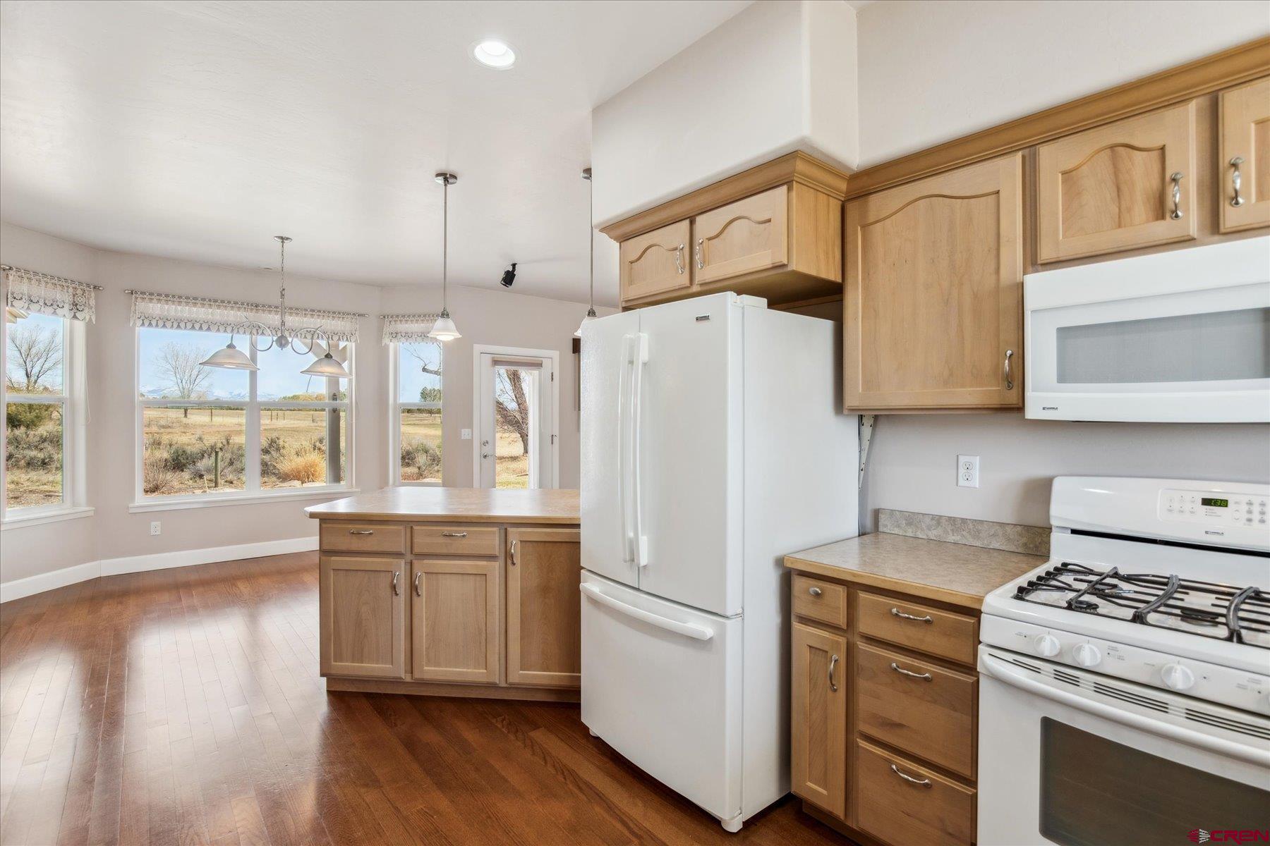 25583 Rd P Dolores, CO 81323 - Photo 12 of 34 a kitchen with stainless steel appliances a refrigerator a stove a sink and white cabinets with wooden floor