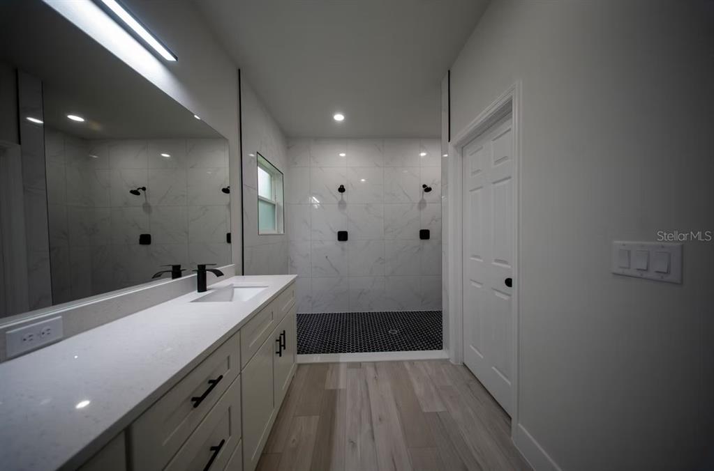 6442 North Sandborn Loop Citrus Springs, FL 34433 - Photo 19 of 33 a bathroom with a sink a large mirror and shower