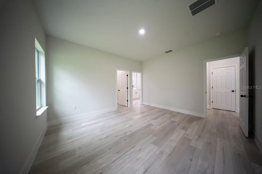 6442 North Sandborn Loop Citrus Springs, FL 34433 - Photo 22 of 33 an empty room with wooden floor and windows