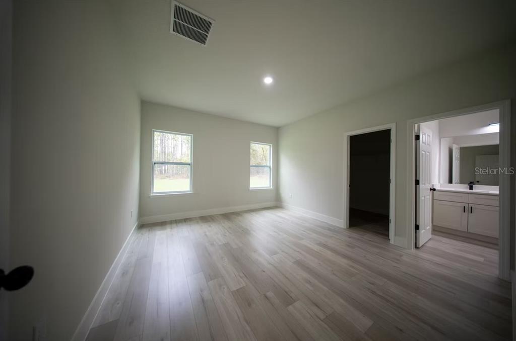 6442 North Sandborn Loop Citrus Springs, FL 34433 - Photo 24 of 33 an empty room with wooden floor and windows
