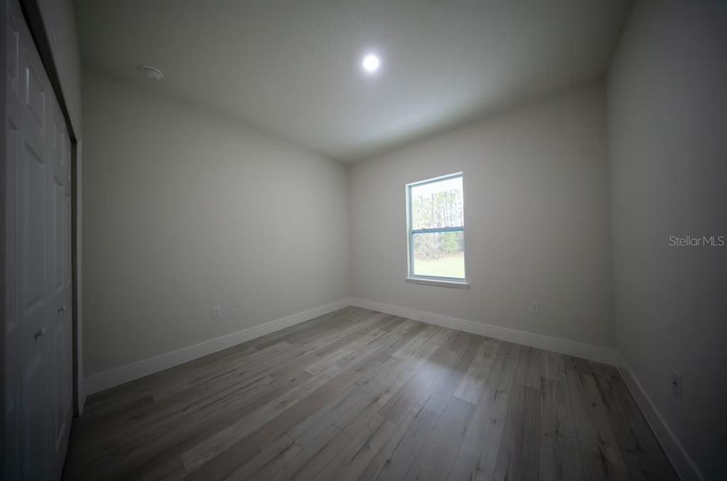 6442 North Sandborn Loop Citrus Springs, FL 34433 - Photo 28 of 33 an empty room with wooden floor and windows