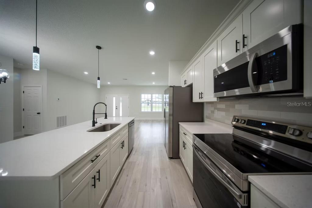 6442 North Sandborn Loop Citrus Springs, FL 34433 - Photo 7 of 33 a kitchen with stainless steel appliances a sink a stove a microwave and cabinets